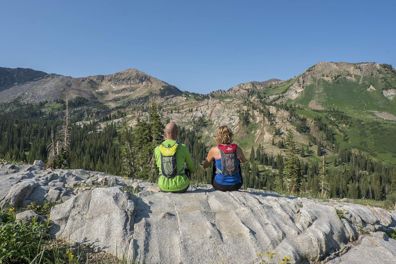 Pareja sentada en la montaña con chalecos de trail de TETON Mexico