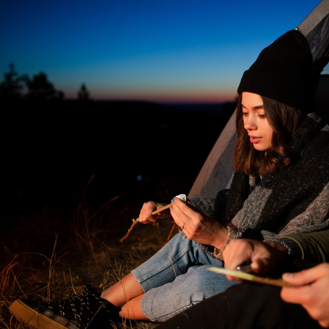 Mujer preparando bombones con chocolate en campamento